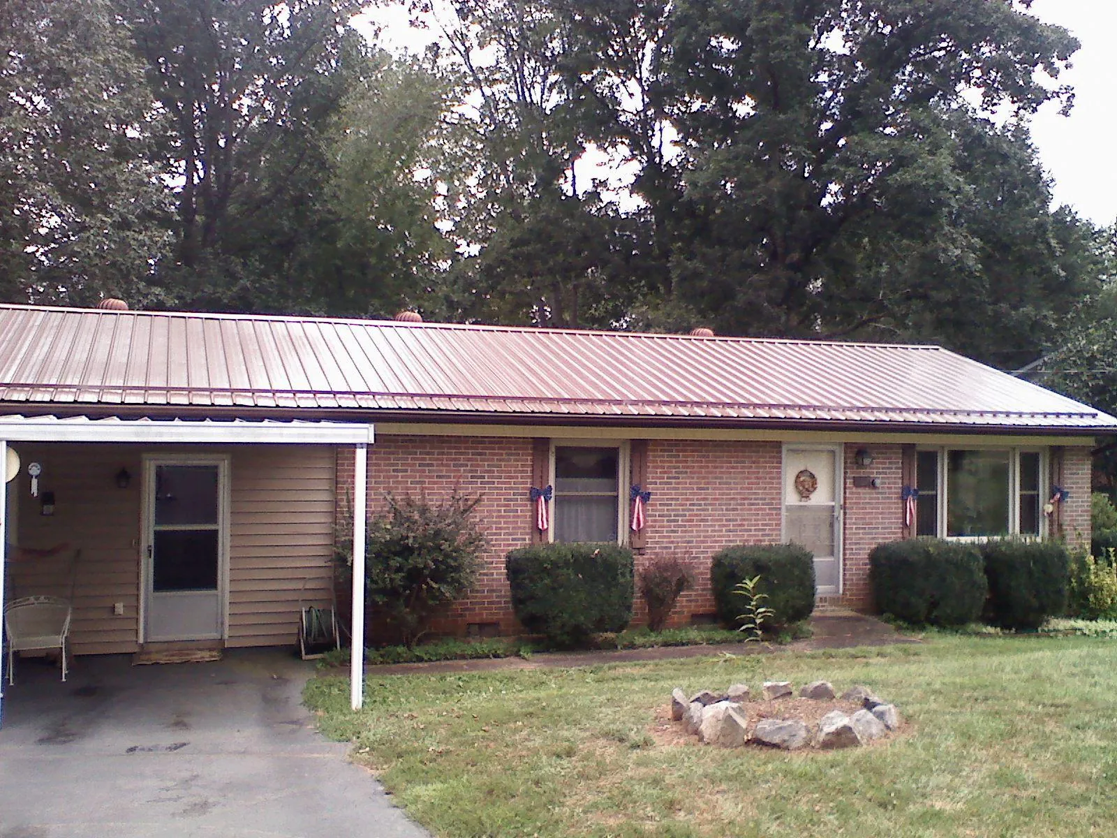Bronze metal roof and carport on a brick ranch home — Roof Repair work by our crew in Vienna